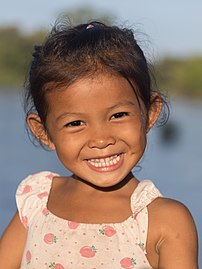 Jeune fille de l'île, souriante, au soleil à l'heure dorée