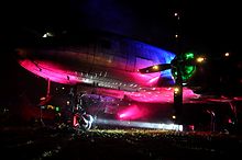 un ancien avion illuminé par des projecteurs multicolores