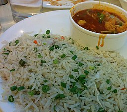 Des légumes à la sauce piquante à l'ail (en haut) et un plat de riz frit, en Inde.