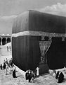 Kaba i Mekka rundt 1910. Døra inn til steinbygningen står to meter over bakken og er delvis dekket av kiswa, et svart teppe med den islamske trosbekjennelsen innvevd