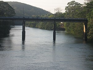 Upstream view of small road bridge over a river, with three supports