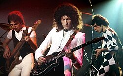 קווין בהופעה בניו הייבן ב-1977. מימין: פרדי מרקיורי, בריאן מיי וג'ון דיקון