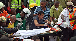 Members of the Tanzanian Red Cross excavate a victim from the rubble Red-cross, 2013 DSM Building Collapse.jpg
