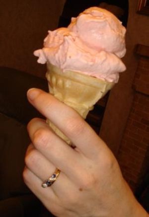 Strawberry ice cream in a cone.