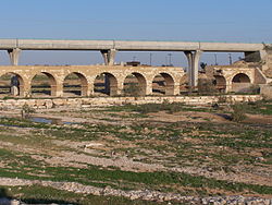 גשר הרכבת הטורקי מעל נחל באר שבע בשנת 2010. מאחוריו גשר רכבת בן זמננו המחבר בין העיר לאזור התעשייה רמת-חובב
