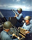 The US Navy Mk II talker helmet, worn by the sailor in the rear-center of the image; The two sailors in the foreground wear the M1 helmet