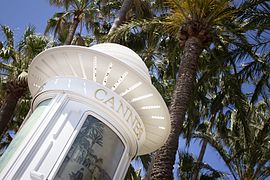 Colonne Morris sous les palmiers de la promenade