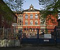 Hauptgebäude der Schule und Toilettengebäude im Hof