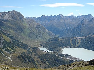 Zeinisjoch mit Vorbecken Zeinis und Stausee Kops vom Osthang der Versalspitze in Blickrichtung Paznaun [T].