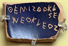 A ballot voting against Themistocles, son of Neocles, under the Athenian Democracy (see ostracism) Inscription: ThEMISThOKLES NEOKLEOS
(classical standard Themistokles Neokleous
Themistokles Neokleous). The text is an example of the epichoric alphabet; the last two letters of Themistocles are written in a boustrophedon manner and that E
and O
are used for both long and short e and o. AGMA Ostrakon Themistocle 3.jpg