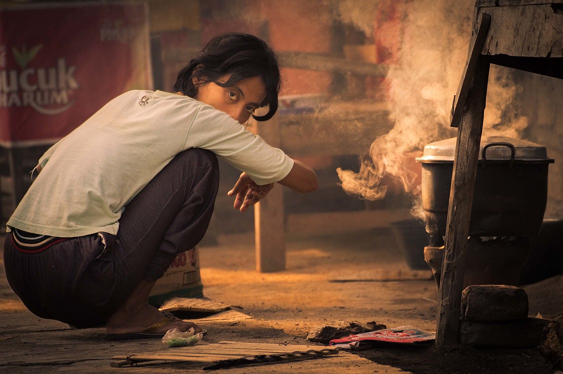 :File:A girl set fire to cook breakfast by using a coal-filled clay pot; July 2014.jpg
