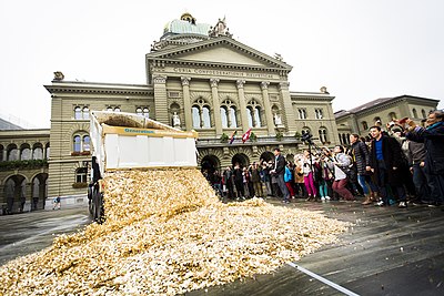 Para pendukung pemasukan dasar di Swiss menuangkan delapan juta koin 5 sen franc Swiss di Bundesplatz, Bern, untuk merayakan keberhasilan mengumpulkan 125.000 tanda tangan untuk mengadakan referendum mengenai pemasukan dasar sejagad