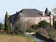 photo éloignée d'un château restituant son aspect d'ensemble. Les tours et la vaste toiture d'ardoise donnent un aspect massif. Des fenêtres de style différent percent la muraille.