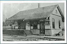 A black-and-white postcard of a small wooden railway station