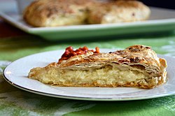 Gibanica single slice with full pie in background.jpg