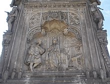 Monument to Columbus, Statue commemorating New World discoveries. Western facade of monument. Isabella at the center, Columbus on the left, a cross on her right. Plaza de Colon, Madrid (1881-85) Monumento a Colon (Madrid) 02c.jpg