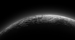 כוכב הלכת הננסי פלוטו בשקיעה, כפי שצולם על ידי החללית ניו הורייזונס ב-14 ביולי 2015. בתצלום ניתן להבחין באזור מישורי המכונה Sputnik Planum (על שם החללית ספוטניק) שגובל בהרי קרח בגובה של כ-3.5 קילומטרים. ההילה השכבתית שניתן לראות מעל פני השטח היא אטמוספירת חנקן המקיפה את פלוטו.