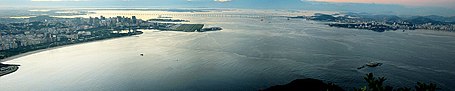 A Panorama taken from Sugarloaf Mountain with a view over the Guanabara Bay. On the left: Rio de Janeiro, on the right: Niterói and in the middle: Santos Dumont Airport. On the background: Rio-Niterói Bridge.