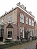 Herenhuis met zij- en achtergevels van ijsselsteen omlopend schilddak met hoekschoorstenen en dakkapellen en bakstenen lijstgevel