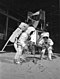 Astronauci Neil Armstrong i Buzz Aldrin podczas ćwiczeń na tle atrapy powierzchni Księżyca i lądownika.