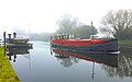 A motorised Dutch barge passing a swing bridge on the Gloucester & Sharpness Canal