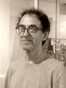 Bust-length image of clean-shaven man with glasses and short hair