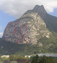 Layout of 4 climbing routes in a vertical wall at the end of a rocky ridge seen from a low angle.