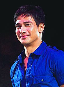 A close angle image of Pascual smiling wearing a blue-collared shirt