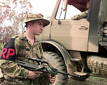 Regimental Policeman of the Australian Army's 9th Royal Queensland Regiment, holding an F88 5.56mm rifle, manning a security check point during exercise Crocodile '99 in the Shoalwater Bay Training Area, Queensland, Australia. Steyr AUG DN-SD-01-04632.jpg