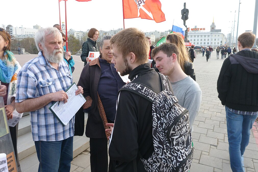 Профессор Алексей Мосин беседует с молодыми прохожими о коммунизме