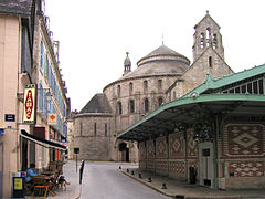 Les Halles (fin XIXe siècle), devant l'église abbatiale Sainte-Croix (fin XIe siècle)