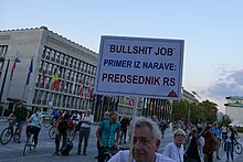 Man with sign that roughly translates to: Bullshit job example from nature: President of the Republic of Slovenia Napisi na protestih v Ljubljani 27. 8., 3. 9. in 10. 9. 2021 34.jpg