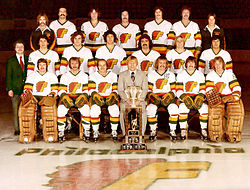 Coach Gregg Pilling in the middle of the front row, with the 1976–77 Philadelphia Firebirds team photo, and the 1976 Lockhart Cup.