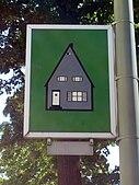 Green sign depicting a gray house.