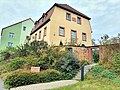 Wohnhaus in halboffener Bebauung und Einfriedungsmauer des Grundstücks