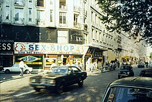 Photographie du boulevard de Clichy. De nombreuses devantures néons de sex-shops et clubs de strip-tease sont visibles