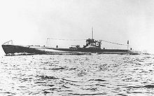 Large submarine running on the surface of the sea with a prominent deck gun and with radio mast raised