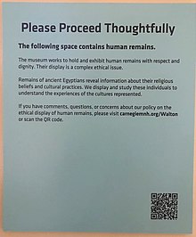 Sign displayed before entering an area of the Walton Hall of Ancient Egypt at the Carnegie Museum of Natural History. The museum invites questions and input regarding ethical displays of human remains. A QR code is featured to access more information. Signage in the Walton Hall of Ancient Egypt at Carnegie Museum of Natural History in Pittsburgh, PA.jpg