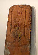 Tuile gravée d'une figure de militaire coiffé d'un shako et portant un sabre[3]