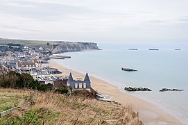 Arromanches vue de l'est, avec les vestiges du port Mulberry dans sa baie, dans le nord.