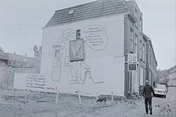 Onthulling van een cartoon van Max van den Berg op een zijmuur van een pand aan de Davidstraat als protest tegen de sloopplannen voor de buurt. Links een tekst van de wijkraad tegen de sloop (1974).