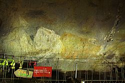 ภาพเขียนสีพระพุทธรูปปางไสยาสน์อยู่บนผนังถ้ำอ้ายเตย์ วัดเทพเจริญ (วัดถ้ำรับร่อ)