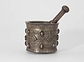 Pestle and mortar made of brass or quaternary copper alloy, piece cast, engraved, ringmatted and inlaid with silver, copper and a black compound.