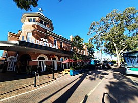 Red brick building next to road with trees