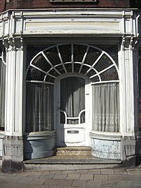 Place du Chenois. Maison du début du XXe siècle ayant conservé une belle devanture et une façade de style Art nouveau[20].