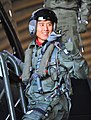 パイロットスーツの上に酸素マスク、ヘルメット、耐Gスーツ、救命胴衣などを着用した姿（F-15K体験搭乗時の具滋哲、2012年）