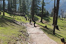 Photo showing children playing tape ball cricket near Pakistani mountains