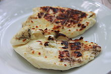 Two slices of grilled white Halloumi cheese on a plate.