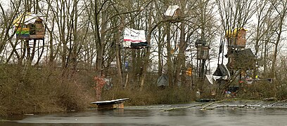 Baumhäuser des Camps „Tümpel-Town“ zwischen dem Südschnellweg und einem Teich, 2024