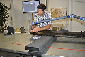 A specialist uses a faro arm to examine a specimen of archaeological wood. Onderzoekmetfaroarm.JPG